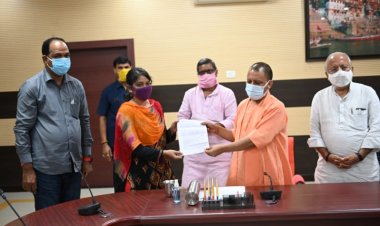 वाराणसी दौरे में मुख्यमंत्री ने मृतक आश्रितों में बांटे नियुक्ति पत्र, बच्चे को भी दुलारा