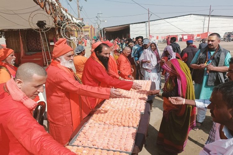 राम मन्दिर की वर्षगाँठ पर निरंजनी अखाड़े में श्रद्धांलुओं कों बाटी गई मिठाई